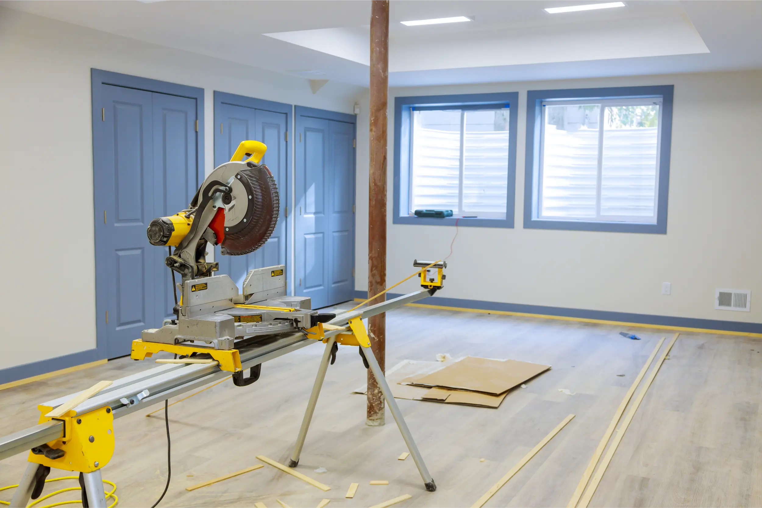A mitre saw set up in an empty room part way through a property refurbishment