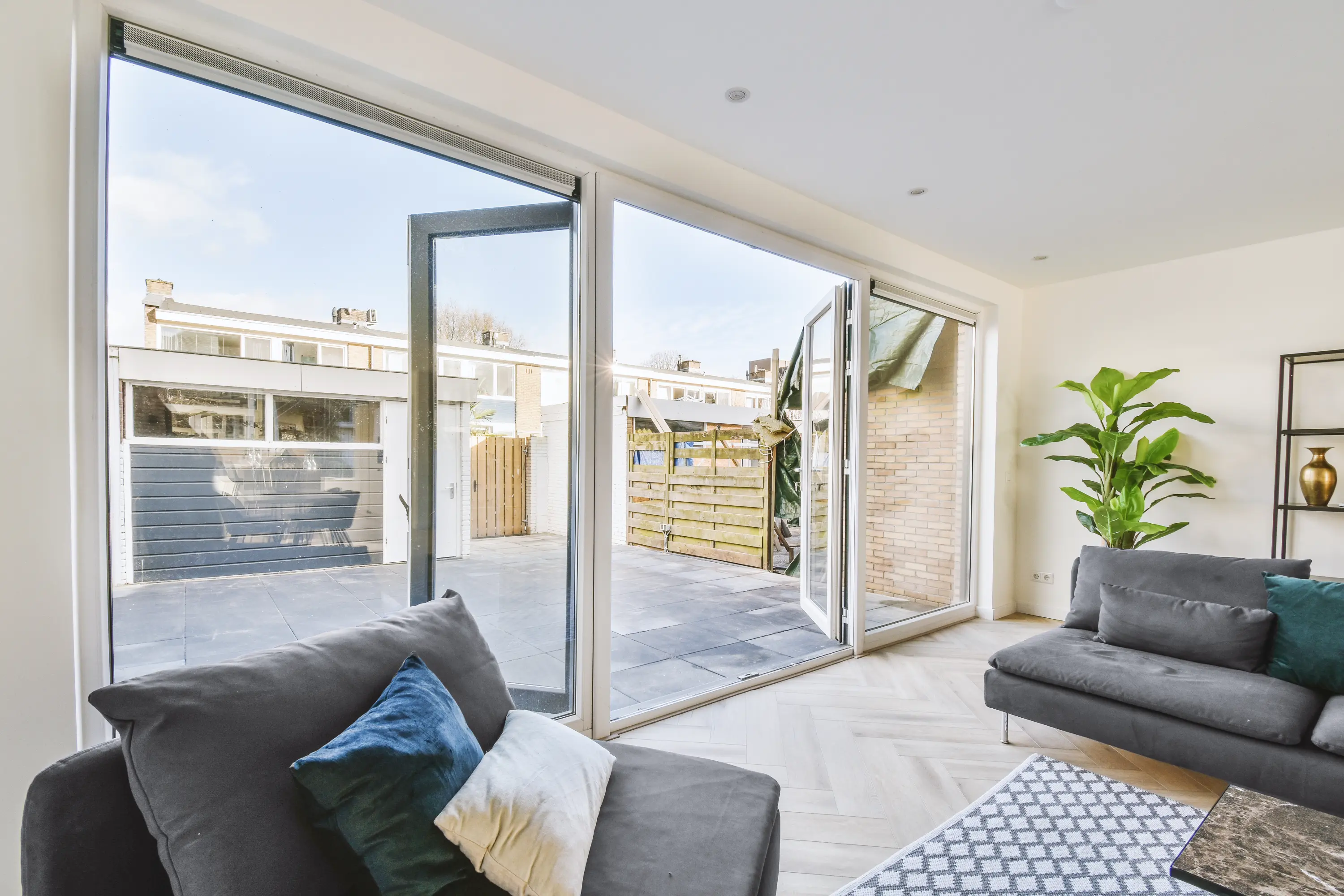 The inside of a finished house extension with full height glazing opening onto a patio