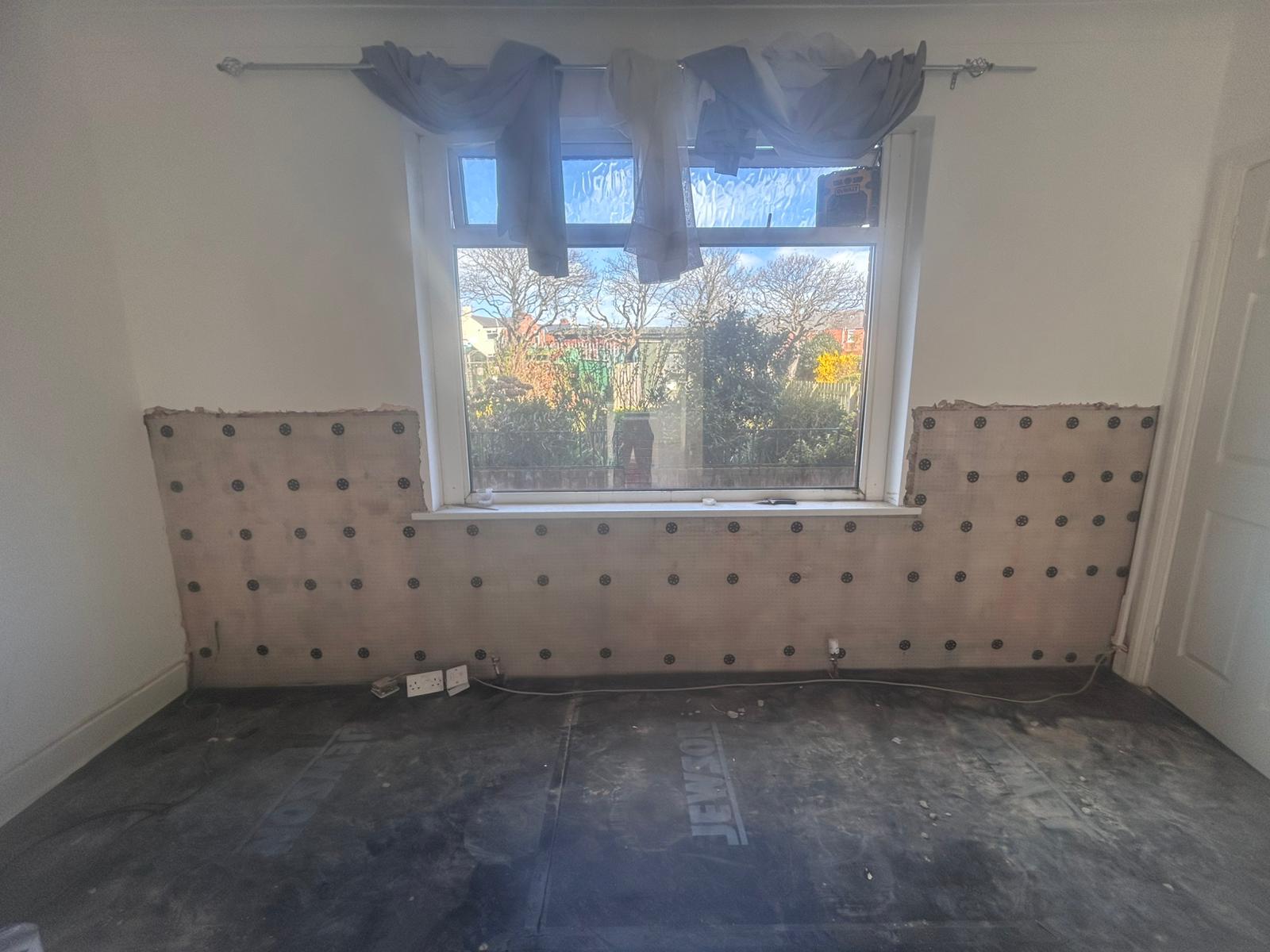 Membrane and plugs fitted below a window as part of a damp proofing system