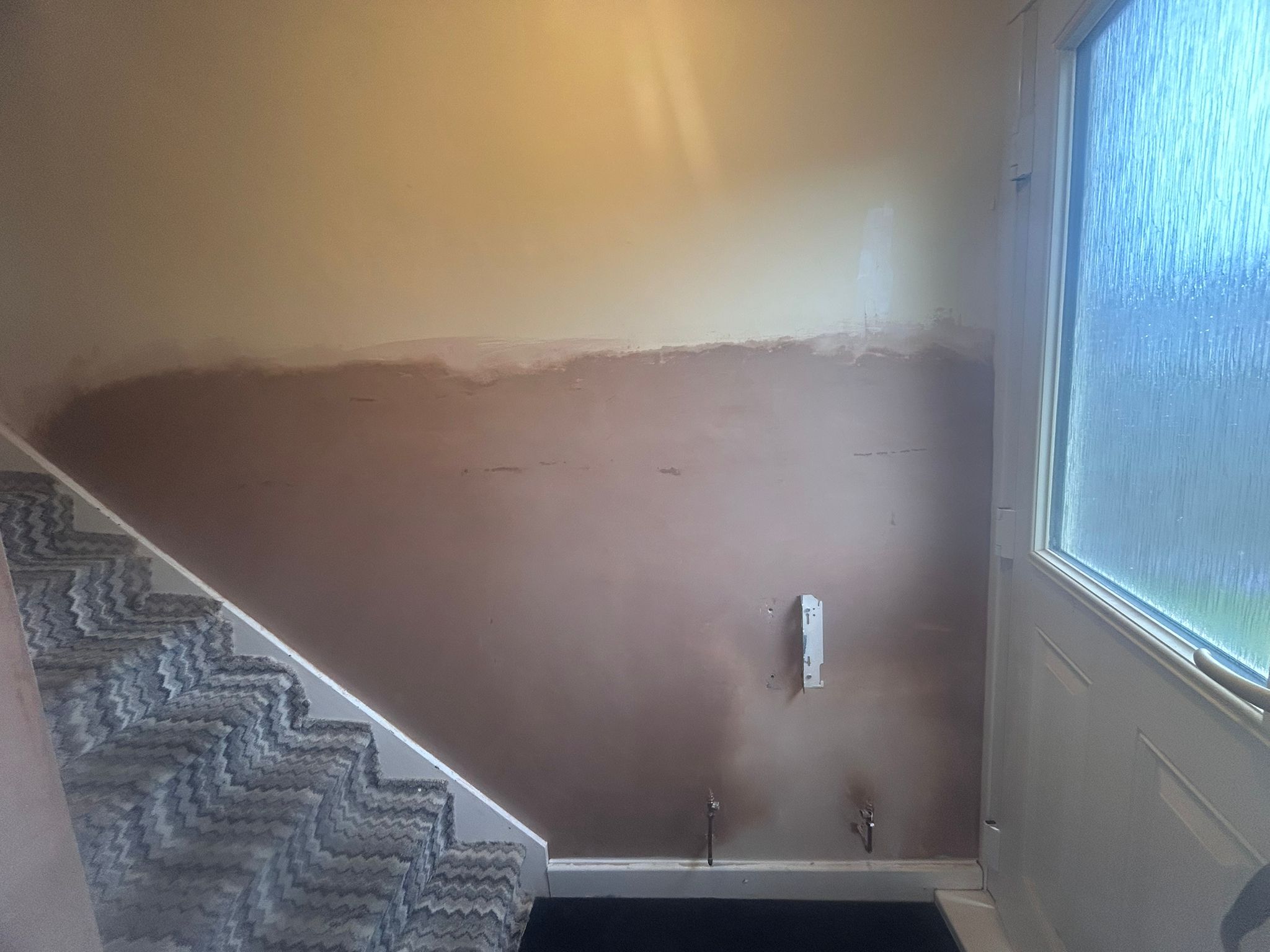 A staircase wall replastered with a smooth finish coat