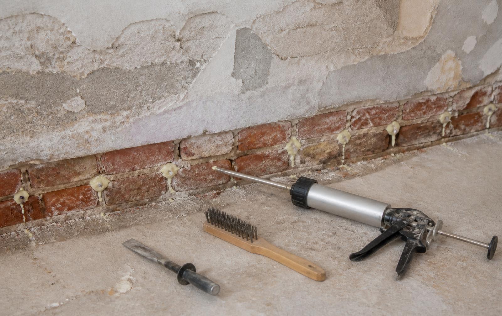 Injecting a chemical damp proof course into the mortar course of a brick wall